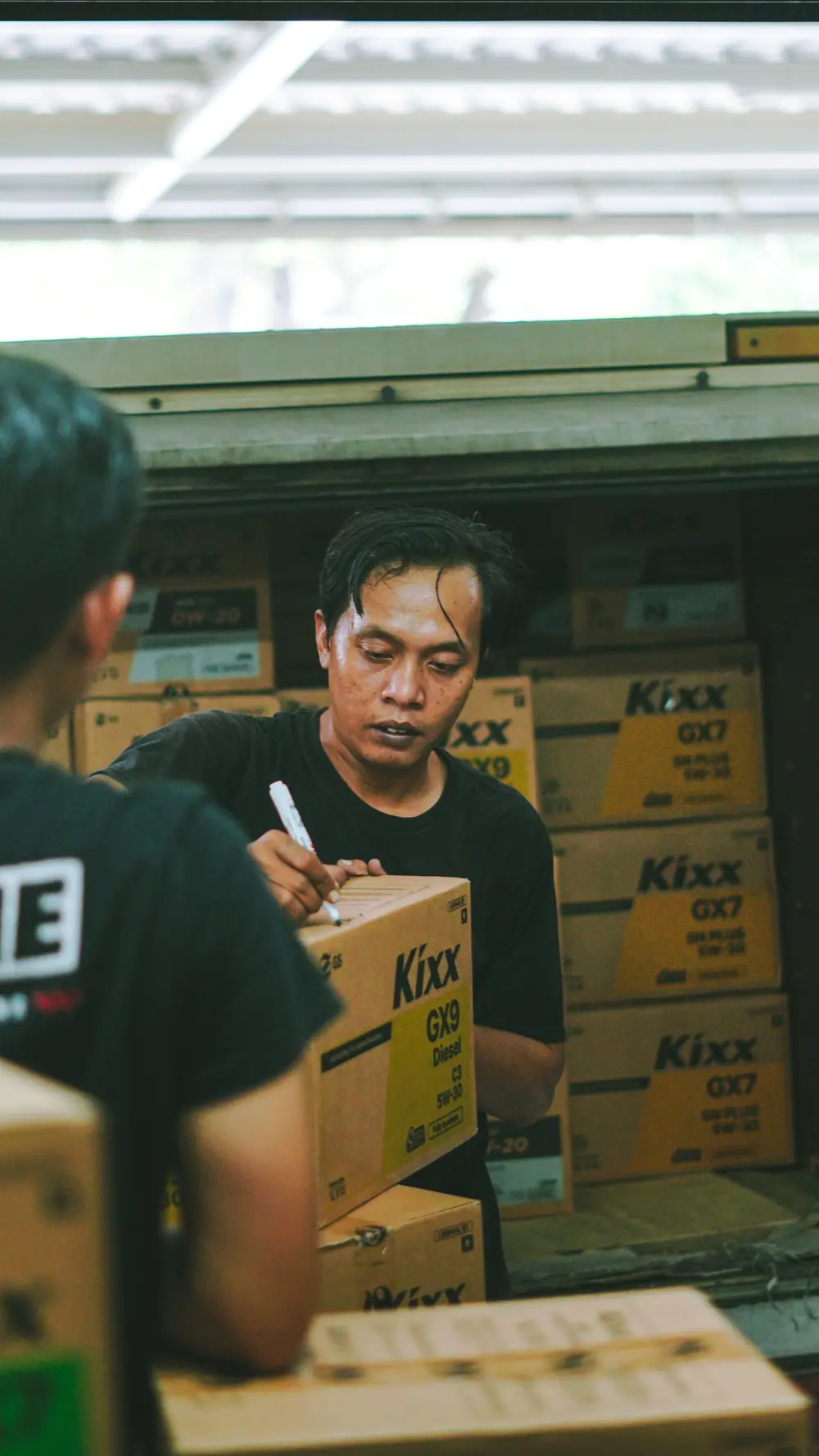 Workers unloading and organizing boxes in a warehouse in Jakarta, Indonesia.